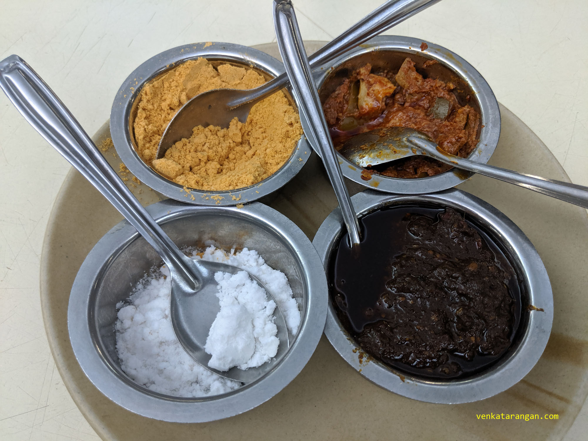 Condiments tray - (Clockwise from left top) Dal Powder to be mixed with Rice; Avakkai Mango Pickle; Gongura pickle; and Salt