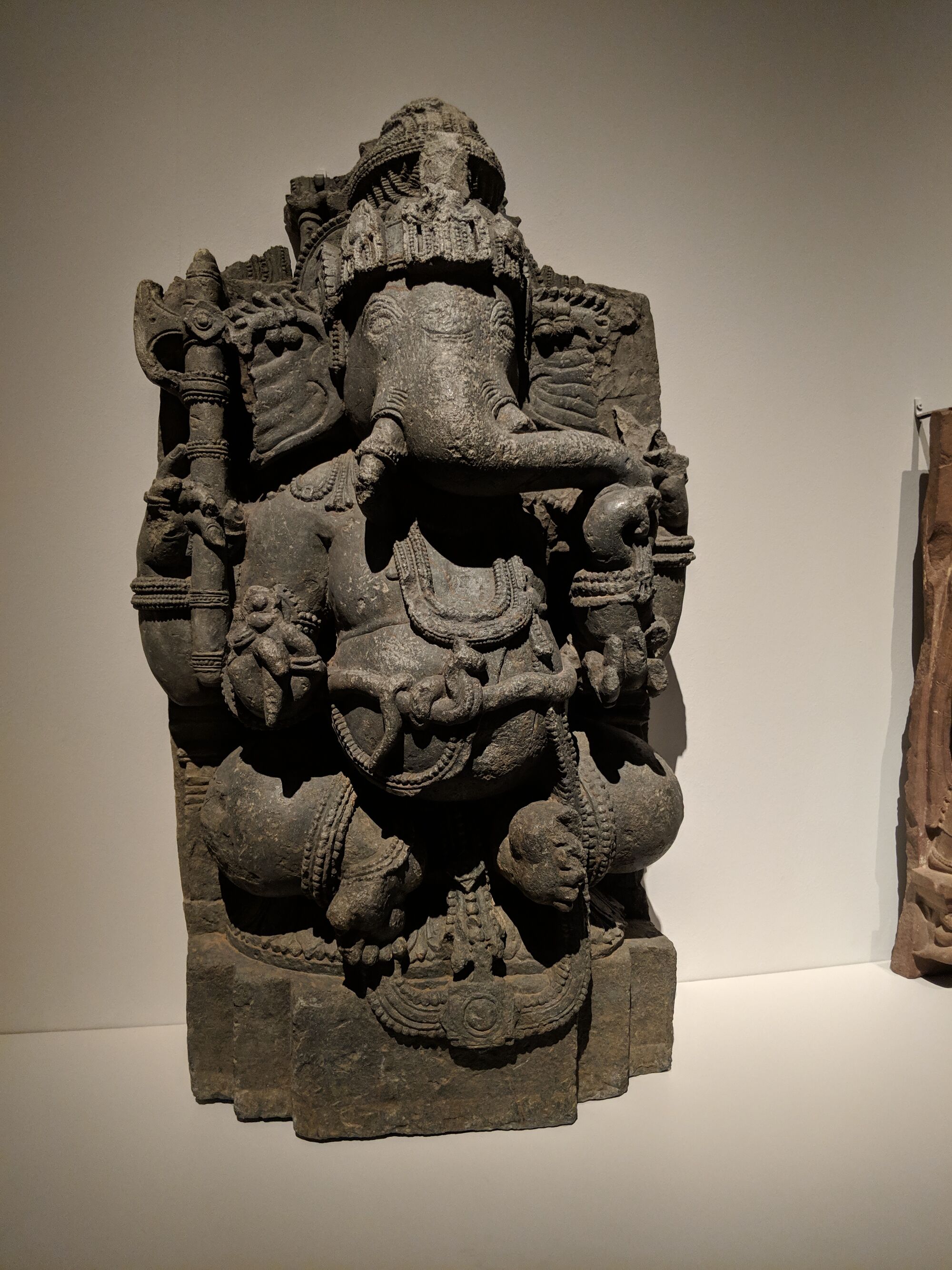 Ganesha, India, Karnataka, 12th century (Hoysala Empire). This four-armed Ganesha uses his trunk to tuck into a bowl of sweetmeats. 
