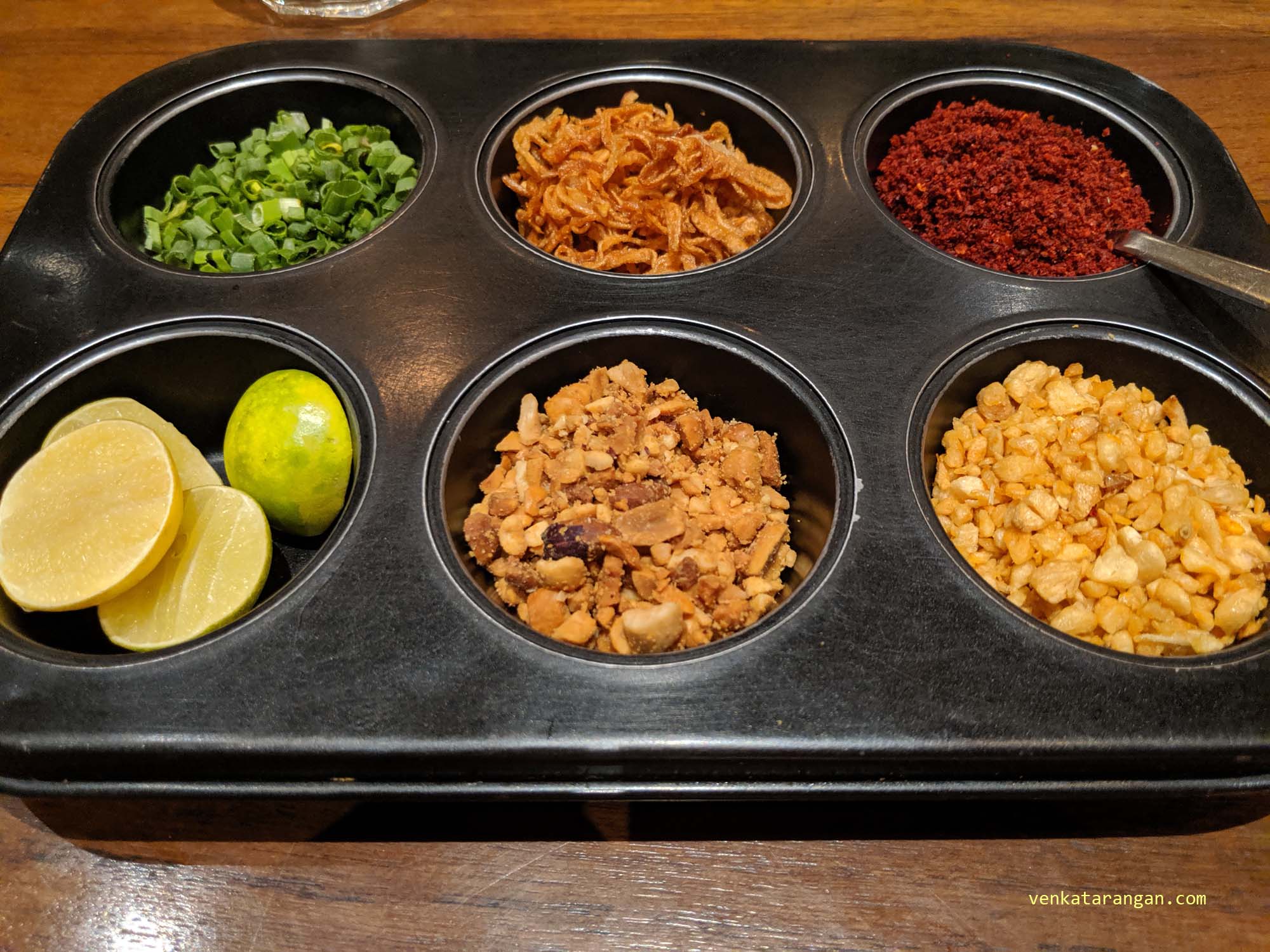 Selection of condiments - cut lime, garlic savoury, red chili powder and roasted onions