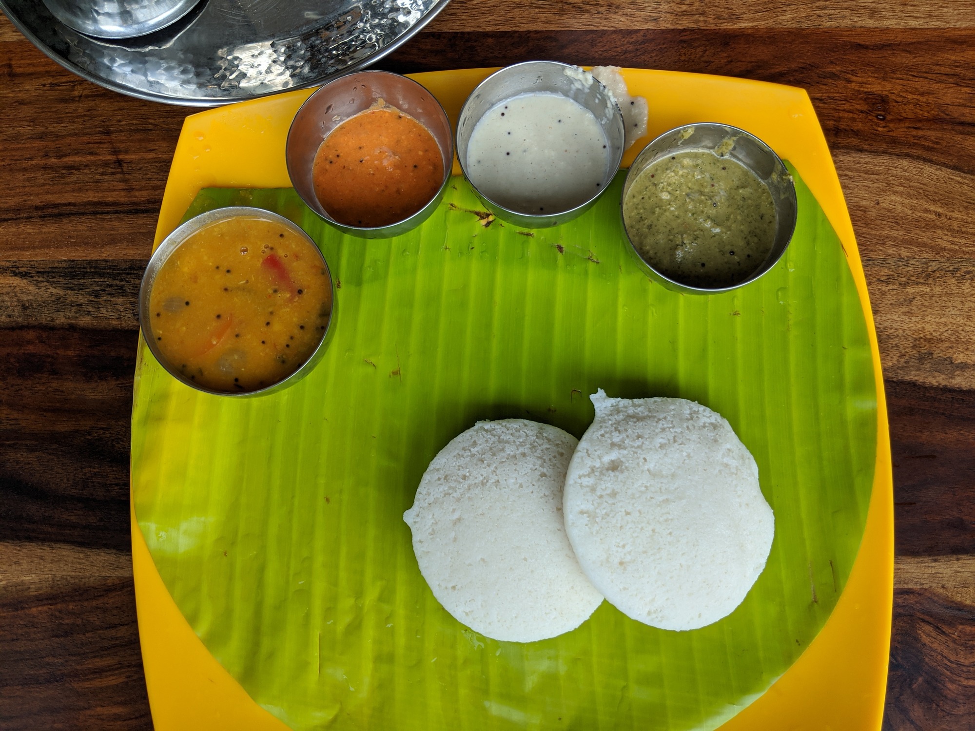 Idli (இட்லி) with Sambar, Tomato Chutney (தக்காளி சட்டினி), Coconut Chutney (தேங்காய் சட்டினி) and Coriander Chutney (கொத்தமல்லி சட்டினி). 