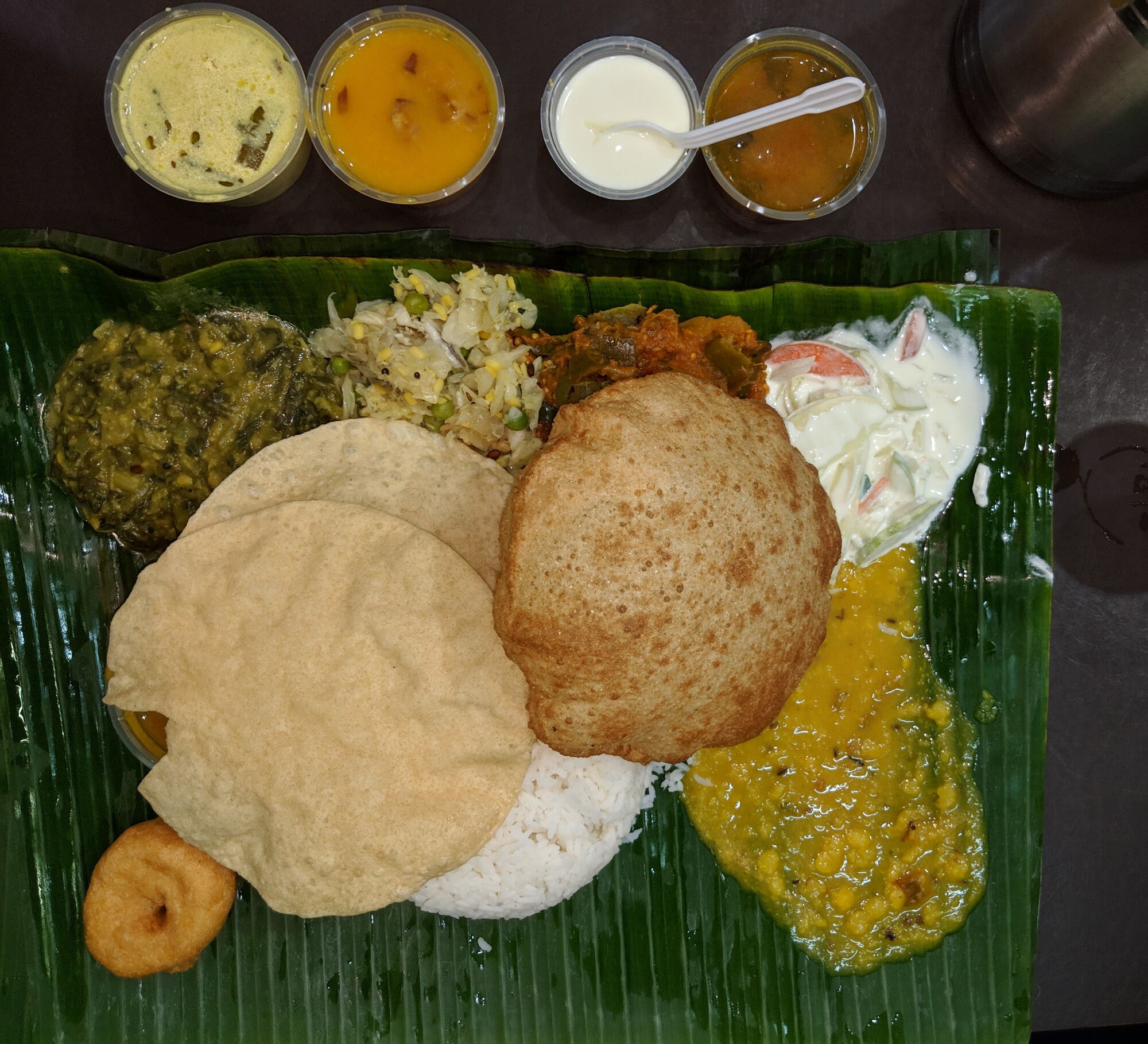 The famous meal of Komala Vilas with Rice, Poriyal, Curry, Sambar, Rasam, Curd, Poori, Vada, Raida and more.